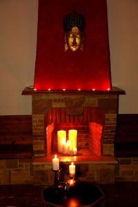 a fireplace with candles and a statue of a head at Edem House in Volos