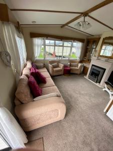 a living room with a couch and a fireplace at Cosy Cottage Caravan in Ashington