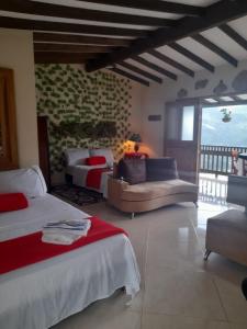 a bedroom with two beds and a couch in a room at Cabaña Noche De Luna in Jardin