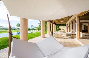 un patio al aire libre con una hamaca y una piscina en Sunny Vacation Villa No 59, en San Rafael del Yuma