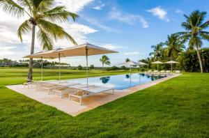 una piscina con tumbonas y sombrillas en un campo en Sunny Vacation Villa No 59, en San Rafael del Yuma