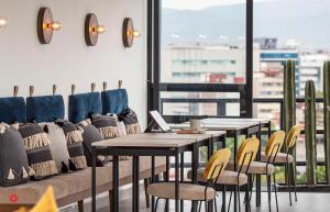 メキシコシティにあるCasa Roma by Kukunのテーブルと椅子と窓のあるダイニングルーム