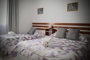 a bedroom with two beds with towels on them at Catalina Hotel in Colón