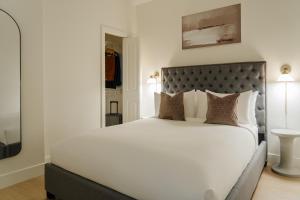 a bedroom with a large white bed with a black headboard at Sonder Ceros in Denver