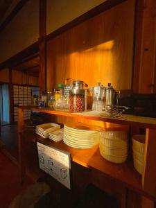 a counter with plates and dishes on a shelf at 三丁庵ゲストハウス 紫陽花祭り会場まですぐ 観光地ペリーロードまですぐの最高なロケーション 下田を遊び尽くせるゲストハウス 無料駐車場もありますJapanese old style guest house that close to Perry road We have long stay plan in Harada