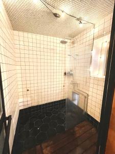 a bathroom with a shower with black and white tiles at 三丁庵ゲストハウス 紫陽花祭り会場まですぐ 観光地ペリーロードまですぐの最高なロケーション 下田を遊び尽くせるゲストハウス 無料駐車場もありますJapanese old style guest house that close to Perry road We have long stay plan in Harada