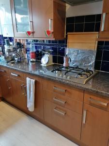 a kitchen with wooden cabinets and a stove top oven at Beautiful and peaceful large double bedroom near Olympic Park in Stratford London in London
