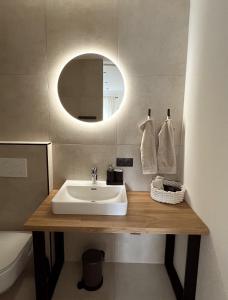 bagno con lavandino e specchio di Ferienwohnung Natters - Your vacation base a Innsbruck