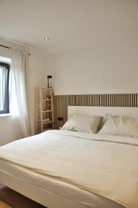 un grande letto bianco in una camera da letto con finestra di Ferienwohnung Natters - Your vacation base a Innsbruck