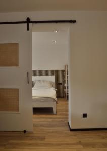 ein Schlafzimmer mit einem Bett durch eine Schiebetür in der Unterkunft Ferienwohnung Natters - Your vacation base in Innsbruck