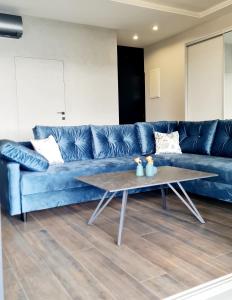 - un canapé bleu dans le salon avec une table basse dans l'établissement Apartamenty Horizon Sunset Boszkowo, à Boszkowo