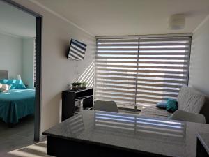 um quarto com uma janela, uma cama e uma secretária em ¡Comodísimo y práctico depto! em Santiago