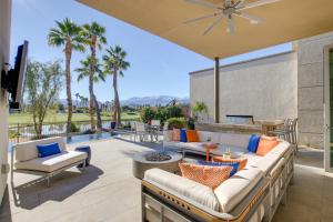 un patio con un sofá, mesas y palmeras en Palm Springs Oasis with Pool and Spa on Golf Course! en Palm Springs