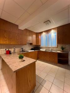 a large kitchen with wooden cabinets and a large island at Στου Στεφανή in Agros