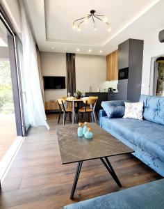 un soggiorno con divano blu e tavolo di Apartamenty Horizon Sunset Boszkowo a Boszkowo