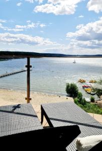 a patio with a table and a view of the water at Apartamenty Horizon Sunset Boszkowo in Boszkowo