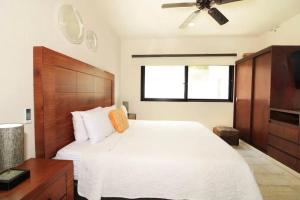 普拉亚卡门Departamento con Jacuzzi en Playa del Carmen的卧室配有一张白色大床和吊扇。 更多56张照片
