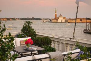 a balcony with a table and chairs with a view of the water at The St. Regis Venice in Venice