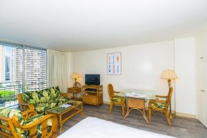 una sala de estar con un sofá y una mesa en Ilikai Marina 1495 City View Studio, en Honolulu