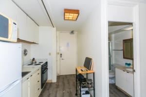 Una cocina con gabinetes blancos y un fregadero. en Ilikai Marina 1495 City View Studio, en Honolulu 13 fotos más