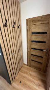 a closet with wooden doors in a room at Apartman City Park Stráňany in Michalovce