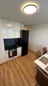 a kitchen with a black refrigerator and a table with chairs at Apartman City Park Stráňany in Michalovce