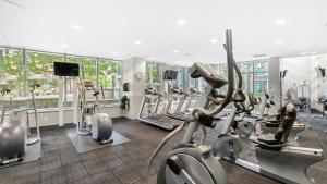 a gym with treadmills and ellipticals in a building at El Tesoro in the Heart of Van w/ Air Con, Pool, and Free Parking in Vancouver