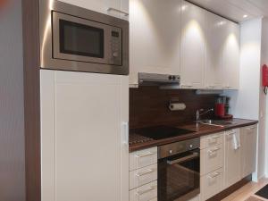 Una cocina con gabinetes blancos y un microondas. en Aparthotel LeviStar, en Levi 10 fotos más