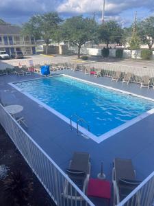 uma grande piscina com cadeiras e um escorrega em Motel 6-Orlando, FL - Winter Park em Orlando