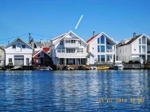 a group of houses next to the water at Helt i Vannkanten as in Åkrehamn