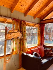 a living room with a couch and a large window at Complejo Jardín De Los Olmos in Villa Giardino