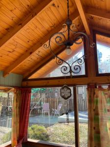 a wooden ceiling with a chandelier in front of a window at Complejo Jardín De Los Olmos in Villa Giardino +59 photos