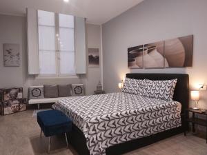 a bedroom with a bed and a couch in it at Appartamento Piazzetta La Maddalena in Savona