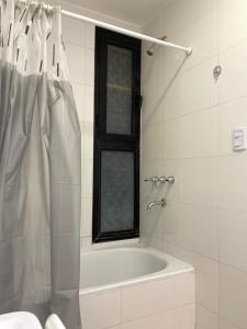 a bathroom with a tub and a shower with a window at Edificio 9 de Julio in San Miguel de Tucumán