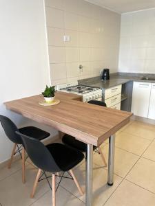 a kitchen with a wooden table and four chairs at Edificio 9 de Julio in San Miguel de Tucumán