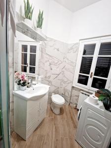 bagno con lavandino, servizi igienici e finestre di Brixia Charm Studio a Brescia
