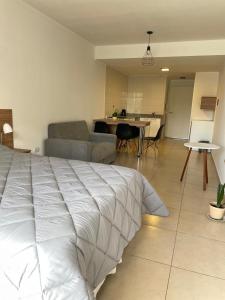 a bedroom with a white bed and a living room at Edificio 9 de Julio in San Miguel de Tucumán