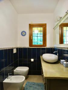 a bathroom with two sinks and a toilet and a mirror at Villa Bel Lago in Bracciano