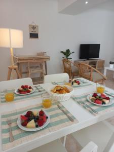 a white table with plates of food on it at Helena's House in Nazaré