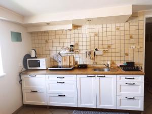 a kitchen with white cabinets and a sink at Pokoje gościnne Zofia Narloch in Władysławowo