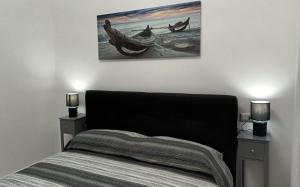 ein Schlafzimmer mit einem Bett und einem Wandgemälde in der Unterkunft La Laguna Rooms in SantʼAntìoco