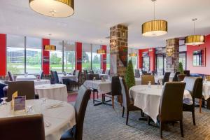Best Western Milton في ميلتون: مطعم بطاولات بيضاء وكراسي ونوافذ