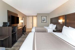 a hotel room with two beds and a flat screen tv at Best Western Milton in Milton