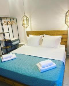 a bedroom with a bed with two towels on it at Galazio Seaside Luxury Rooms & Coffee Shop in Platamonas