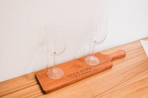 two wine glasses sitting on a wooden cutting board at Starlight bungalow queen 4 in El Porvenir