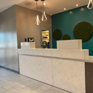 a lobby with a white counter and a green wall at Best Western San Bernardino Hotel in San Bernardino