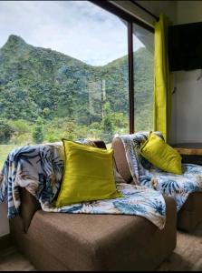 a couch with yellow pillows sitting in front of a window at Pika Cabins 1 in San Carlos