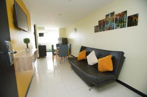 ein Wohnzimmer mit einem schwarzen Ledersofa und einem Tisch in der Unterkunft Apartamento con piscina cerca al parque del café in Montenegro