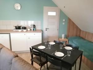 a dining room table with chairs and a kitchen at Zlatno 66 in Zlaté Moravce