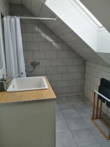 baño con lavabo y suelo de baldosa blanca en Zlatno 66, en Zlaté Moravce
